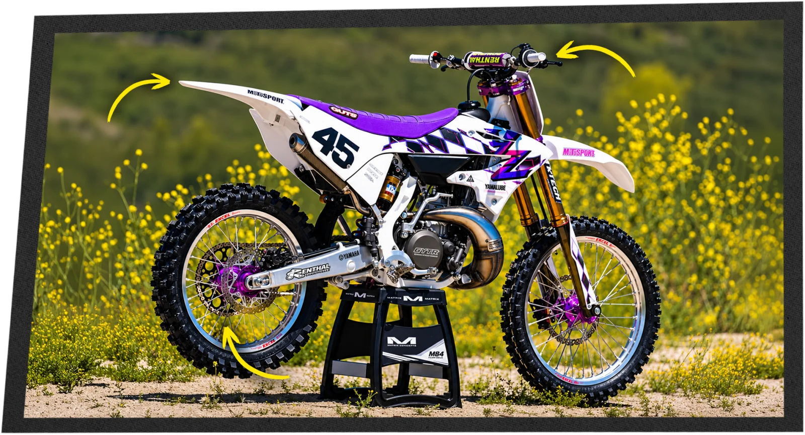 The finished 50th Anniversary Yamaha YZ250 on a stand in a field of yellow flowers